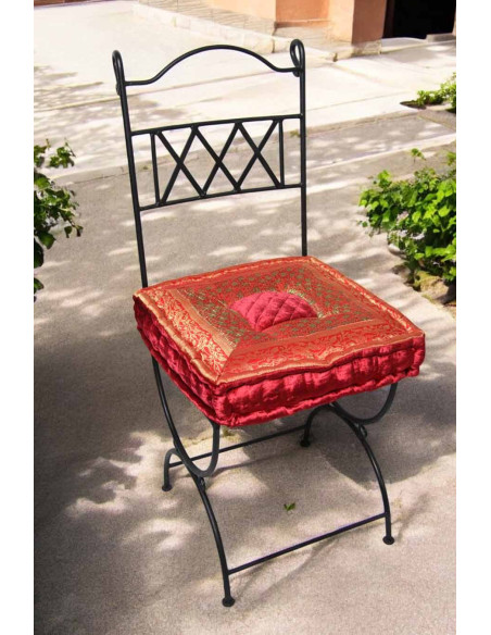 Wrought iron chair with red-orange cushion
